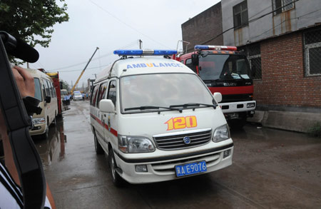 An ambulance with injured people leaves the site where a factory under construction collapsed and dozens of people were trapped at Xizhaotong Town, Shijiazhuang City, capital of north China's Hebei Province, on August 4, 2009.