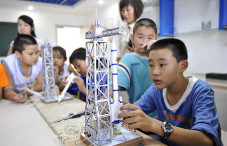 Pupils make models at the Children's Science Palace in Qingshan District, Baotou City, north China's Inner Mongolia Autonomous Region, on August 2, 2009. 