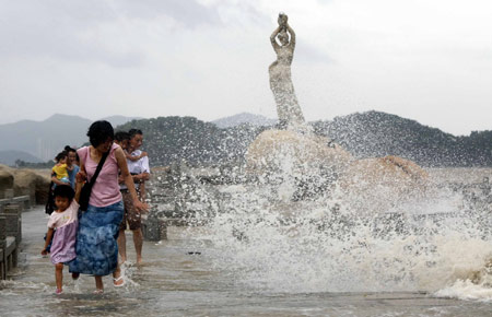 Chinese tourists escape from the ocean waves splashing on a trestle bridge on the beach near Zhuhai city in south China's Guangdong Province, on August 4, 2009 as the tropical storm of 'Goni' approaches to the city.