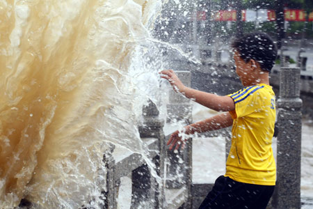 A Chinese boy escapes from an ocean wave splashing on a trestle bridge on the beach near Zhuhai city in south China's Guangdong Province, on August 4, 2009 as the tropical storm of 'Goni' approaches to the city.