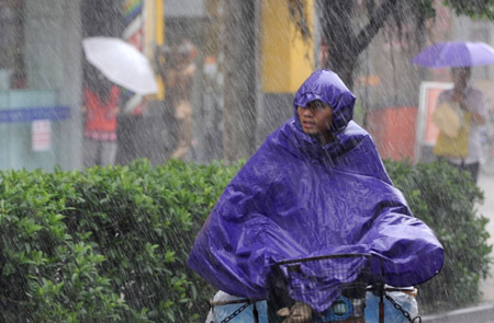 A local rides a bicycle in the rain in Guangzhou, capital of south China's Guangdong Province, on Aug. 5, 2009. The tropical storm Goni landed at a speed of 83 km per hour early Wednesday morning in Taishan of Guangdong Province, according to local meteorological station. Meteorologists also said another tropical storm, Morakot, which formed on the west Pacific Ocean Tuesday morning, was now moving at 20 km per hour northwestward. (Xinhua/Lu Hanxin)