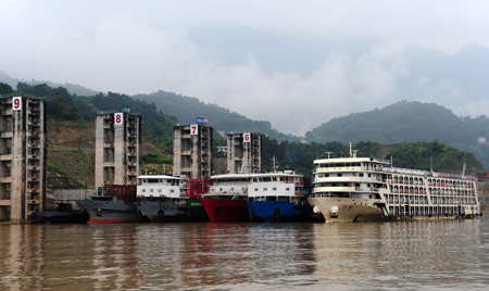 Cargo ships berth at Lanlingxi Anchorage Ground and wait to pass the Three Gorges ship locks in Zigui county of central China's Hubei Province, on August 4, 2009. Because of the biggest flood peak, the water influx into the Three Gorges Reservoir reached 42,000 steres per second up to 8:00 PM on August 3, and the Three Gorges ship locks were closed. 