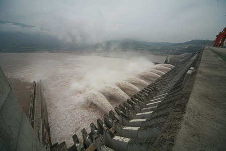 Photo taken on August 4, 2009 shows a sluice discharging water on the Three Gorges Dam in Zigui county of central China's Hubei Province, on August 4, 2009.