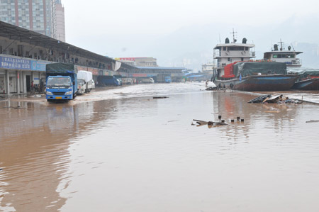 The repository of a logistics company is submerged by flood in southwest China's Chongqing Municipality, on August 4, 2009. The continual heavy rainfalls in Chongqing brought about flood over the city, with many lower sections of the riverside streets submerged.