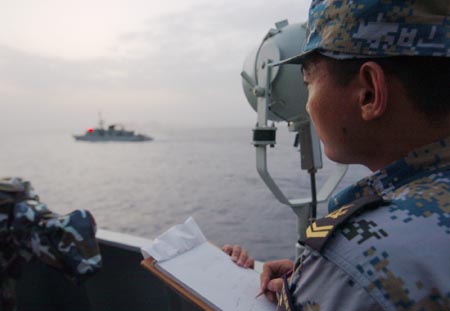 A Chinese navy soldier aboard the Zhoushan missile frigate says hello via light signal to Saudi Arab's Abha missile frigate on the Gulf of Aden, on August 4, 2009. Two frigates and a supply ship from the Chinese navy is on their escort mission to fend off Somali pirates on the Gulf of Aden. 