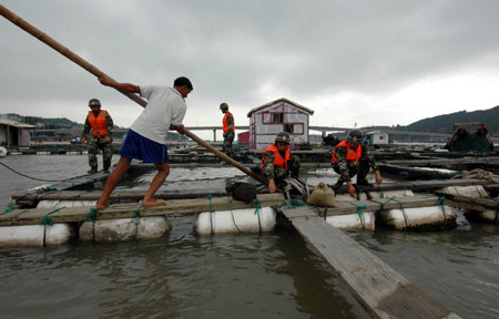 Soldiers help fishermen strengthen rafts in Wenzhou City, east China's Zhejiang Province, on August 6, 2009. 