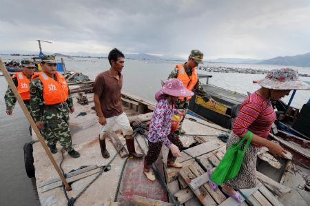 Members of local police help fishermen evacuate to the shore in Fuzhou, capital of southeast China's Fujian Province, on August 6, 2009. The eye of Typhoon Morakot was located at 840 kilometers east of Fuzhou City as of 11:00 AM on Thursday. 