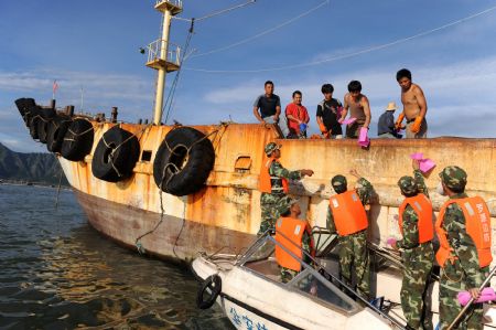 Members of local police direct fishermen to go to the shore in Fuzhou, capital of southeast China's Fujian Province, on August 6, 2009. The eye of Typhoon Morakot was located at 840 kilometers east of Fuzhou City as of 11:00 AM on Thursday. 