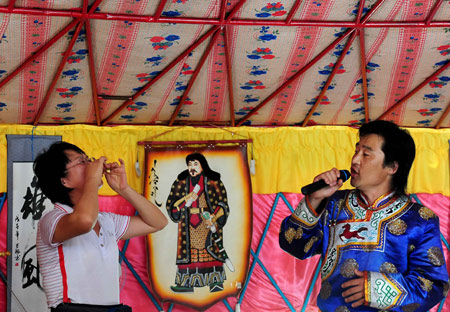 A singer sings a song for tourists in a Mongolian yurt in Horqin Youyi Qianqi, north China's Inner Mongolia Autonomous Region, on August 6, 2009. 