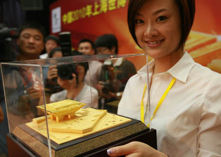 An employee presents a gold model of 'China Pavilion' in Shanghai, east China, on August 6, 2009. The first gold model of 'China Pavilion' of Shanghai 2010 World Expo was issued on Thursday. 