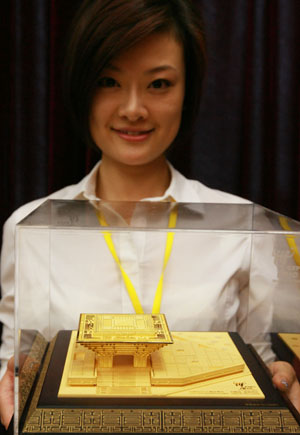 An employee presents a gold model of 'China Pavilion' in Shanghai, east China, on August 6, 2009. The first gold model of 'China Pavilion' of Shanghai 2010 World Expo was issued on Thursday. 