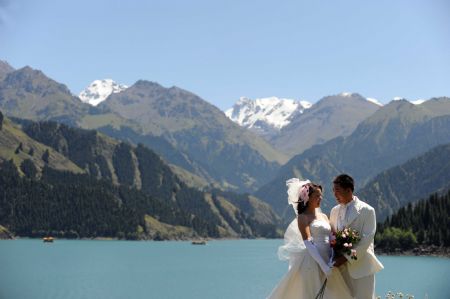 A new couple take wedding photos at the Tianchi Lake in the Tianshan Mountains of northwest China&apos;s Xinjiang Uygur Autonomous Region, on August 8, 2009. 
