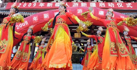 Actresses perform dance during a tourism promotion ceremony at the Tianchi Lake in the Tianshan Mountains of northwest China&apos;s Xinjiang Uygur Autonomous Region, on August 8, 2009.