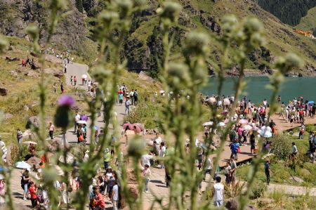 Tourists visit the Tianchi Lake in the Tianshan Mountains of northwest China&apos;s Xinjiang Uygur Autonomous Region, on August 8, 2009.