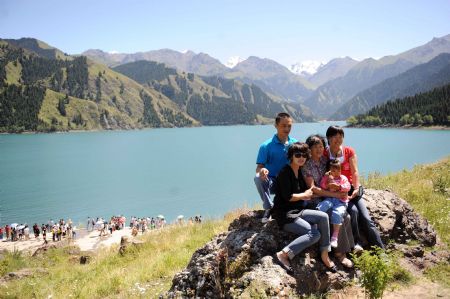 A family pose for photos at the Tianchi Lake in the Tianshan Mountains of northwest China&apos;s Xinjiang Uygur Autonomous Region, on August 8, 2009.