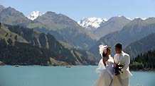 A new couple take wedding photos at the Tianchi Lake in the Tianshan Mountains of northwest China's Xinjiang Uygur Autonomous Region, on August 8, 2009.