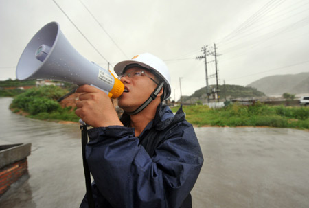 A man calls for people to evacuate to avoid typhoon in Cangnan County, east China's Zhejiang Province, on August 8, 2009. The province has evacuated around 317,000 people to avoid the approaching Typhoon Morakot so far.