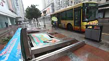 A local bus stops next to a street bulletin stand broken by heavy wind and rain hours prior to the landing of typhoon Morakot at Rui'an City in east China's Zhejiang Province on August 9, 2009. Typhoon Morakot gains momentum and is expected to hit provinces in east China later Sunday.