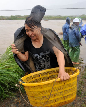 A woman saves cultured mudskippers at Hongshan Village in Xiapu County, southeast China's Fujian Province, on August 9, 2009.