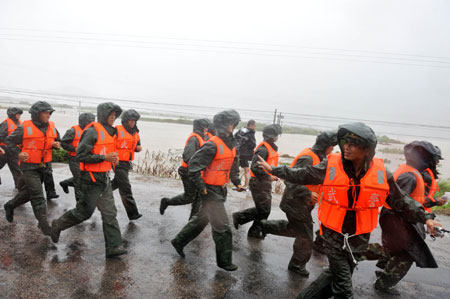 Armed policemen work as rescuers at Hongshan Village in Xiapu County, southeast China's Fujian Province, on August 9, 2009. 