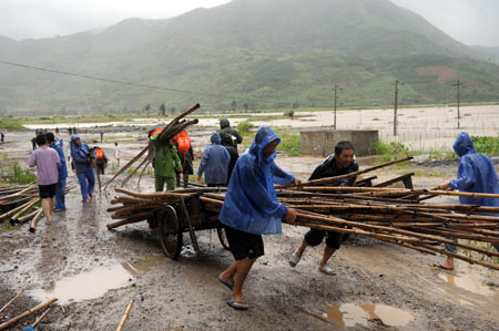 Armed policemen help villagers to evacuate materials at Hongshan Village in Xiapu County, southeast China's Fujian Province, on August 9, 2009.