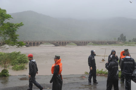 Rescuers guard beside the Qidu River at Hongshan Village in Xiapu County, southeast China's Fujian Province, on August 9, 2009. 