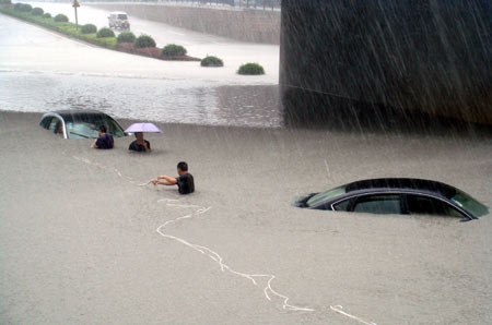 Rescuers pull a car out of water in rain in Wenzhou, east China&apos;s Zhejiang Province, on August 9, 2009. Typhoon &apos;Morakot&apos; slammed into Chinese provinces on the eastern coast on Sunday, causing casualties, destroying houses and inundating farmlands