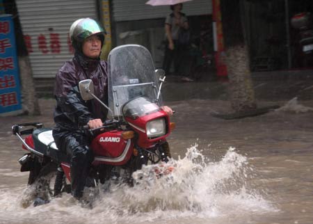 A man rides motorbike on a flooded street in Wenling, east China&apos;s Zhejiang Province, on August 9, 2009. Typhoon &apos;Morakot&apos; slammed into Chinese provinces on the eastern coast on Sunday, causing casualties, destroying houses and inundating farmlands.