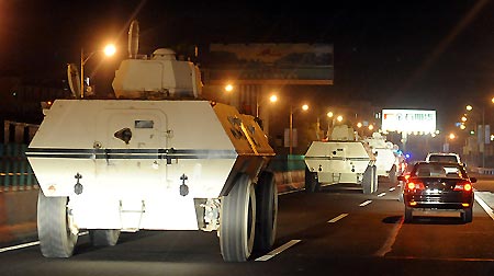 Armored vehicles withdraw from the Urumqi airport, northwest China's Xinjiang Uygur Autonomous Region, early August 10, 2009, after the airport was restored to order. 