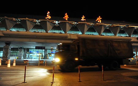 Armored vehicles withdraw from the Urumqi airport, northwest China's Xinjiang Uygur Autonomous Region, early August 10, 2009, after the airport was restored to order.