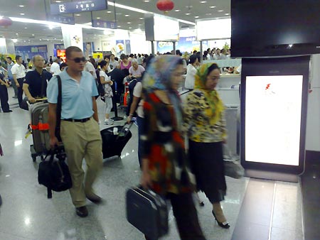 Passengers walk in the Urumqi airport, northwest China's Xinjiang Uygur Autonomous Region, early August 10, 2009, after the airport was restored to order. 