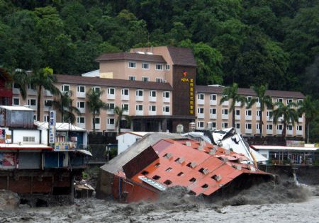 A collapsed hotel building is seen in floods after Typhoon Morakot hit eastern Taiwan on August 9, 2009. The six-story hotel collapsed and plunged into a river Sunday morning after floodwaters eroded its base, but all 300 people in the hotel were evacuated and uninjured, officials said.