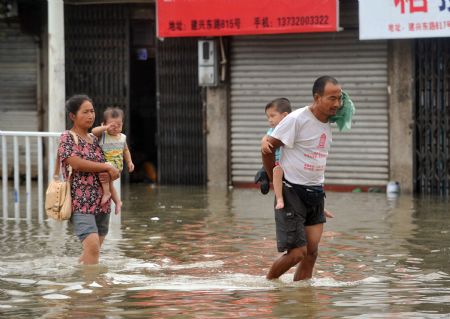 Pedestrians wade through the flooded street in Cangnan, east China's Zhejiang Province, on August 10, 2009.