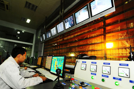 Workers work at a workshop of Anshan Iron and Steel Group Corporation (Angang) in Anshan, northeast China's Liaoning Province, on August 2, 2009. 