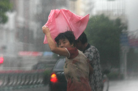 People walk in heavy rain in Jiaojiang of Taizhou city, east China's Zhejiang Province, on August 9, 2009. Typhoon 'Morakot' slammed into Chinese provinces on the eastern coast on Sunday, causing casualties, destroying houses and inundating farmlands.