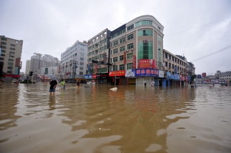 Pedestrians wade through the flooded street in Cangnan, east China's Zhejiang Province, on August 10, 2009. Rains brought by typhoon Morakot, the 8th typhoon of the year, flooded the Cangnan county.