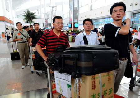 Passengers wait to get on board at a port in Xiamen, southeast China's Fujian Province, on August 10, 2009. The navigation in Xiamen restored after Typhoon Morakot left the area.