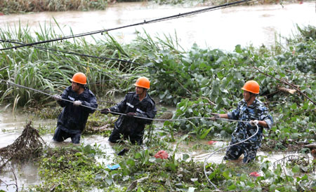 Power technicians draw a wire rope to reestablish power tower destroyed by Typhoon Morakot at Ruian, east China&apos;s Zhejiang Province, on August 10, 2009. The local government organized the people in the typhoon-stricken area to rebuild their homes on monday right after the Typhoon faded away.