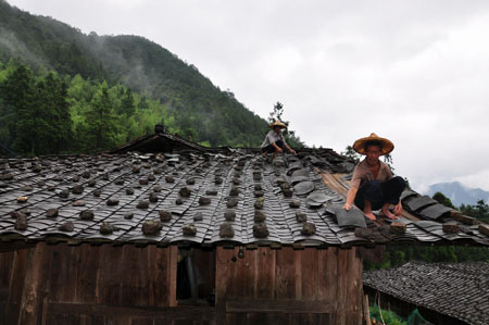 A couple of villagers reorganized roof of their house destroyed by Typhoon Morakot at Shangzhai Village of Dehua County, southeast China&apos;s Fujian Province, on August 10, 2009. The local government organized the people in the typhoon-stricken area to rebuild their homes on monday right after the Typhoon faded away. 