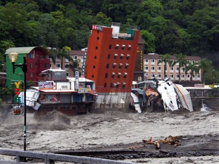 A hotel building leans before falling in a heavily flooded river after Typhoon Morakot hit eastern Taiwan, on Sunday, August 9, 2009.