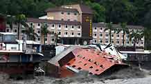 A collapsed hotel building is seen in floods after Typhoon Morakot hit eastern Taiwan on August 9, 2009. The six-story hotel collapsed and plunged into a river on Sunday morning after floodwaters eroded its base, but all 300 people in the hotel were evacuated and uninjured, officials said.