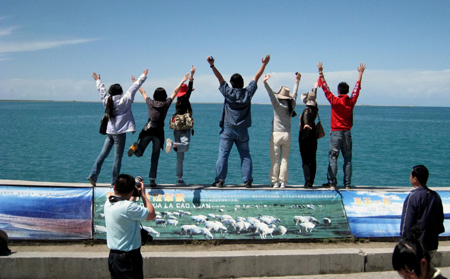 Tourists enjoy themselves by the Qinghai Lake, about 150 kilometers west of Xining, capital of northwest China's Qinghai Province, on August 13, 2009. Located in northeastern part of the Qinghai-Tibet Plateau with an altitude of over 3,200 meters, the Qinghai Lake, covering an area of 4,300 square km, is the largest inland salt-water lake in China as well as an important ecological and natural reserve