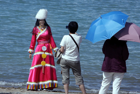 Tourists enjoy themselves by the Qinghai Lake, about 150 kilometers west of Xining, capital of northwest China's Qinghai Province, on August 13, 2009.