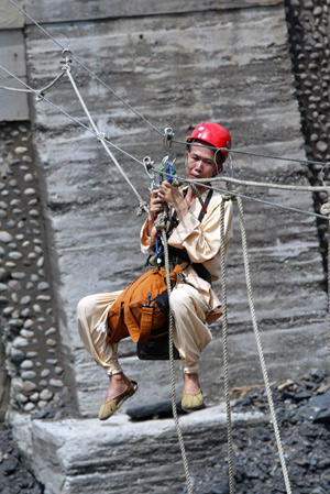 A rescue worker moves past a ruined bridge by temporary steel ropes for relief work on the road to Xinkai village in Kaohsiung of Taiwan, on August 12, 2009. 