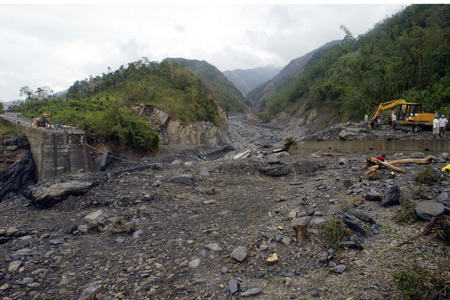 Rescue workers work for disaster relief near a ruined bridge on the road to Xinkai village in Kaohsiung of Taiwan, on August 12, 2009