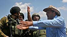 A Palestinian protestor (R) argues with Israeli soldiers during a protest in West Bank city of Nablus, on August 14, 2009.