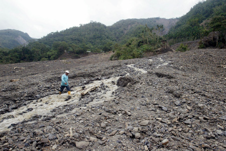 A villagers searches for lost belongings in a damaged village in Kaohsiung, southeast China's Taiwan Province, Aug. 14, 2009