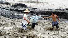Villagers search for lost belongings in a damaged village in Kaohsiung, southeast China's Taiwan Province, on August 14, 2009.
