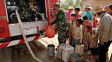 Villagers wait for water sent by firemen at Lancha Village, Tianping Township of Xiji County, northwest China's Ningxia Hui Autonomous Region, on August 14, 2009.