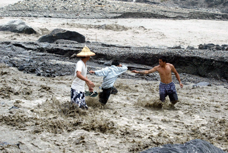 Villagers search for lost belongings in a damaged village in Kaohsiung, southeast China's Taiwan Province, on August 14, 2009. 